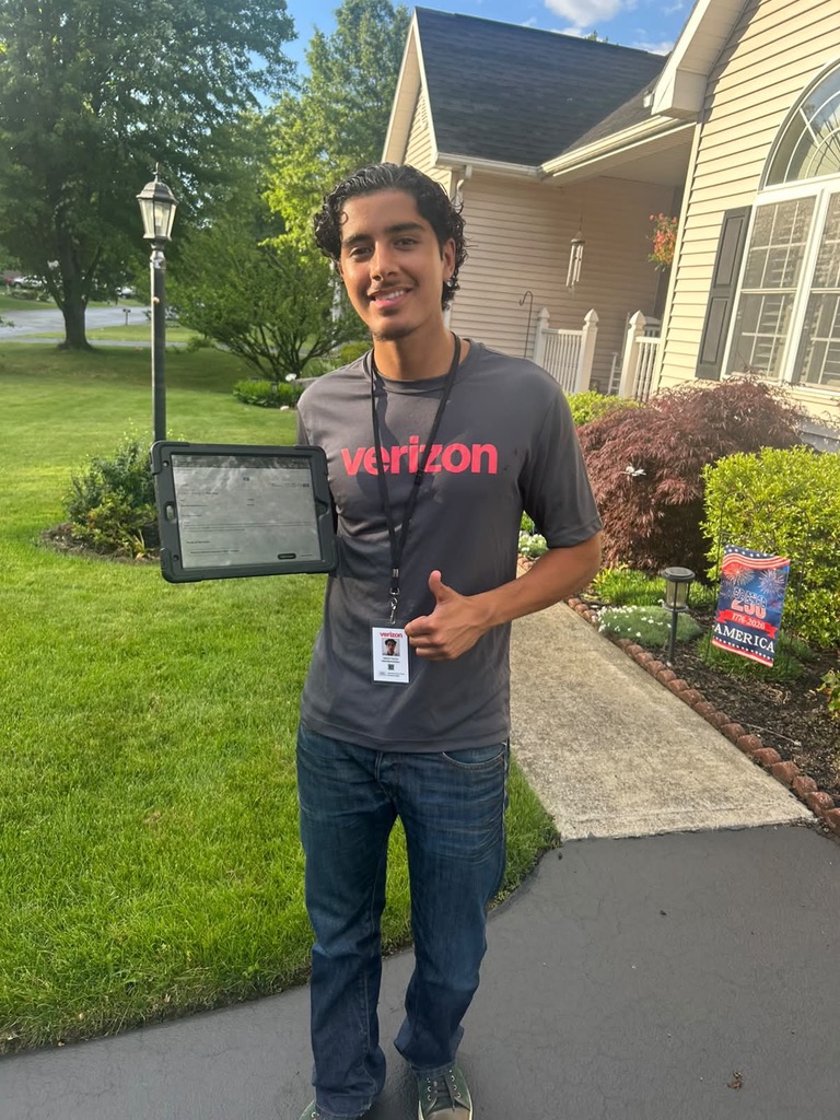 Nordic Sales Group door to door sales rep holding a tablet and giving a thumbs up outside a customer home